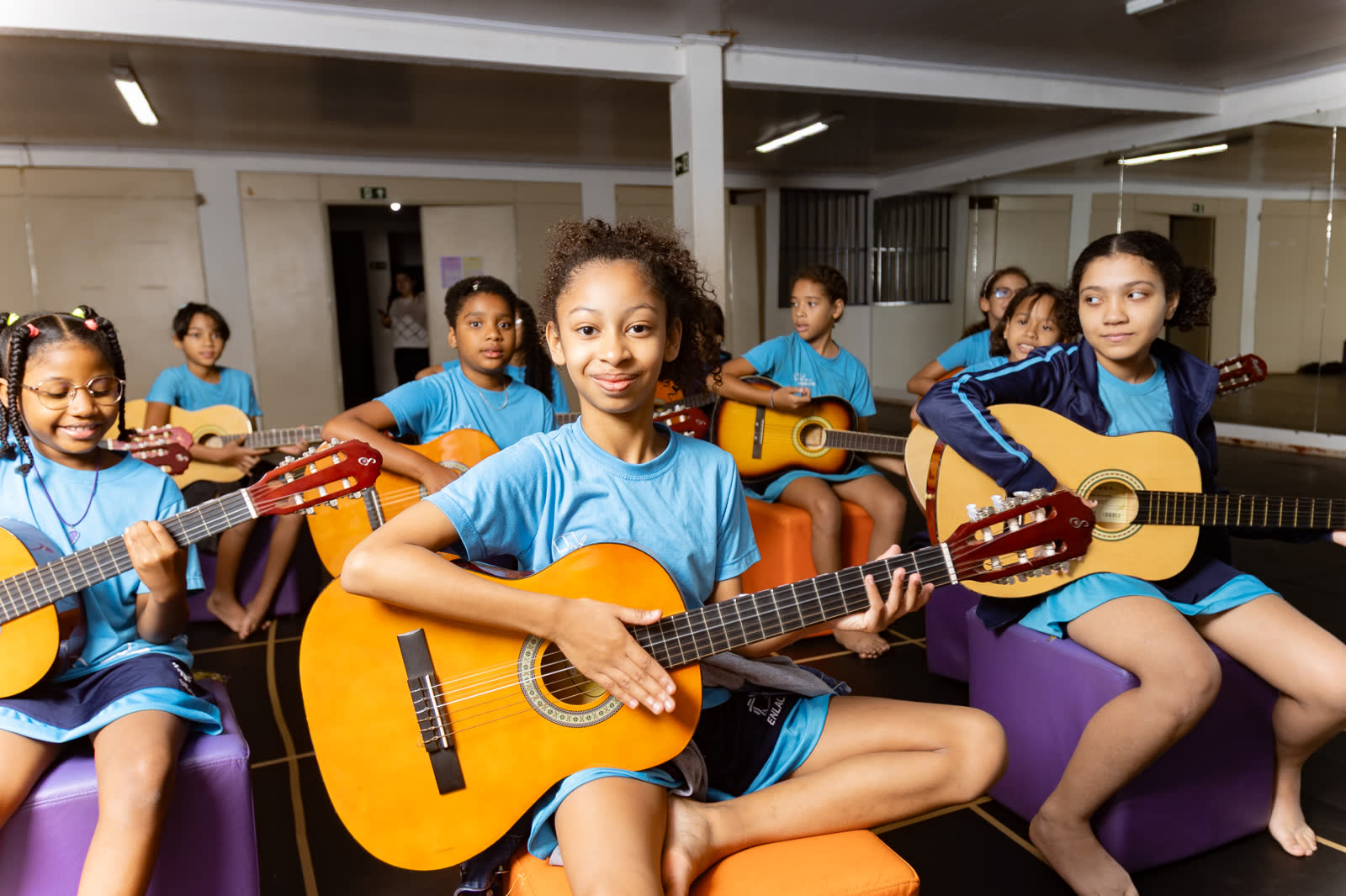 Crianças participando de oficina de violão da Enlace